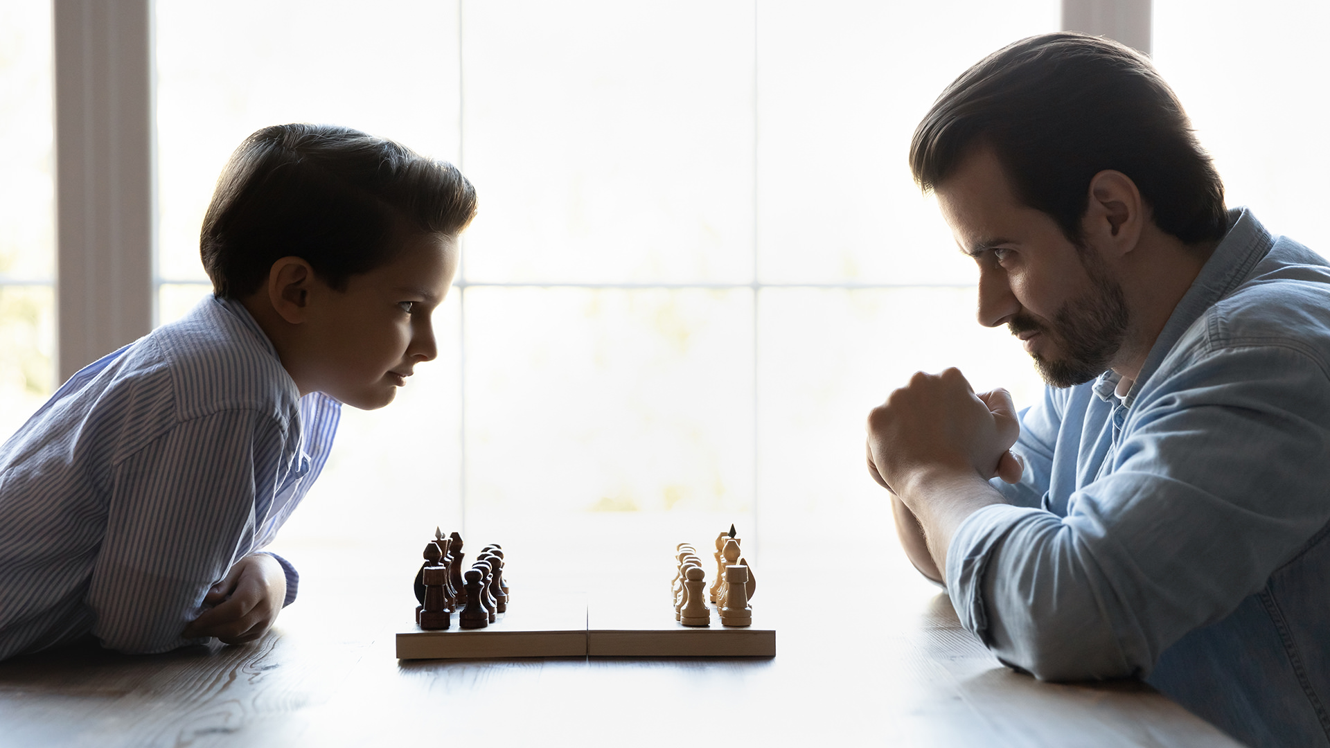 Boy playing chess with a man