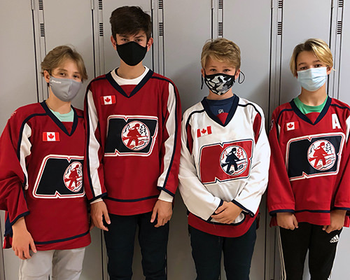 Noah's friends wearing their hockey jerseys in front of school lockers